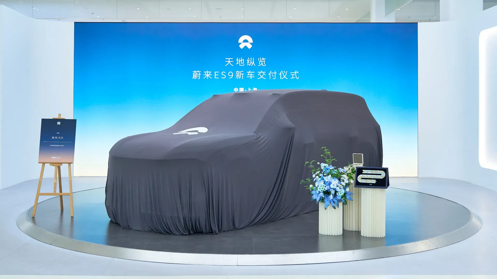 A covered Nio ES9 sits on stage ahead of its unveiling at Yao Ming's Shanghai delivery ceremony.