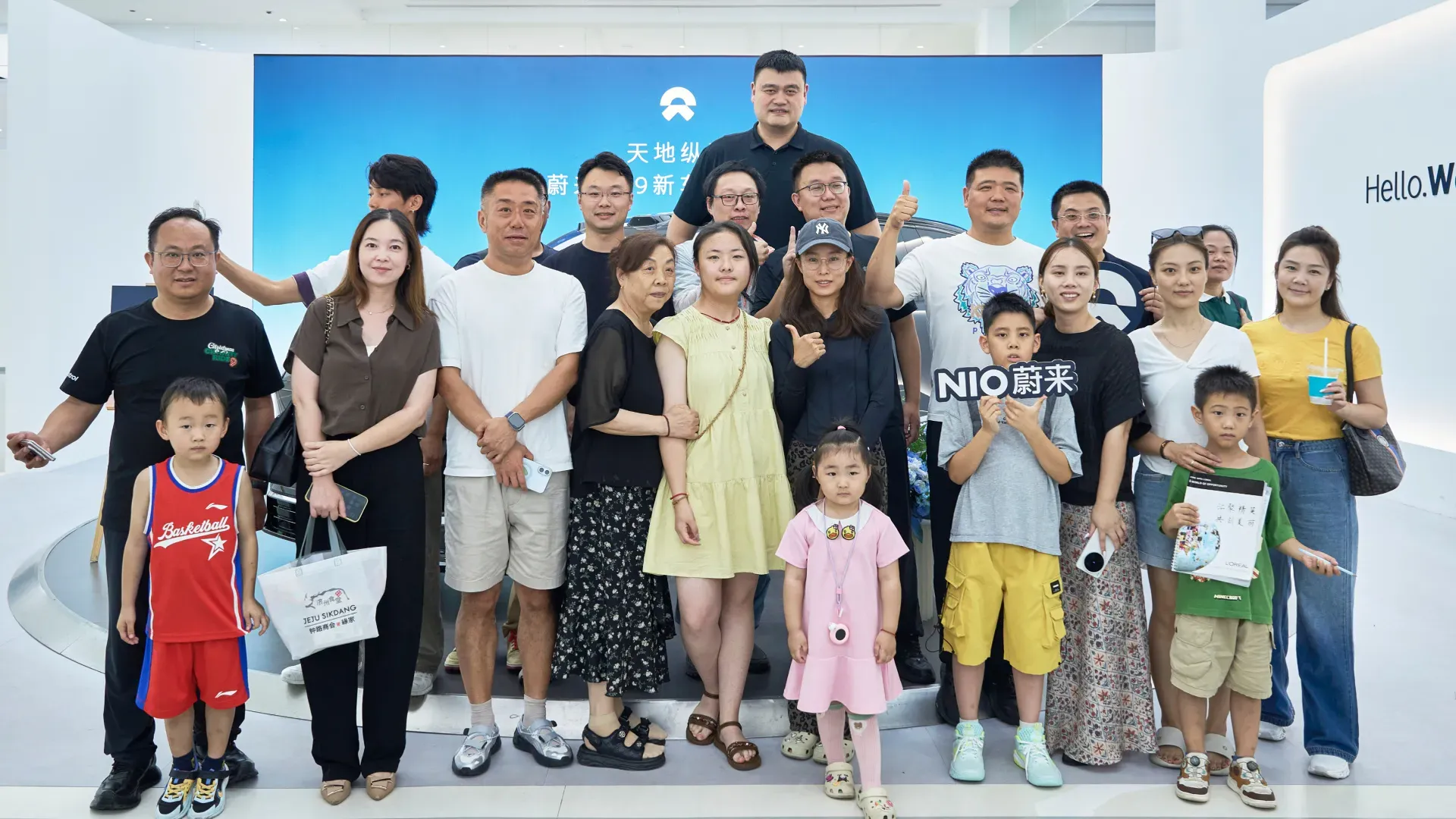 Yao Ming towers over a group of fellow Nio ES9 owners and their families posing together at the Shanghai delivery event.
