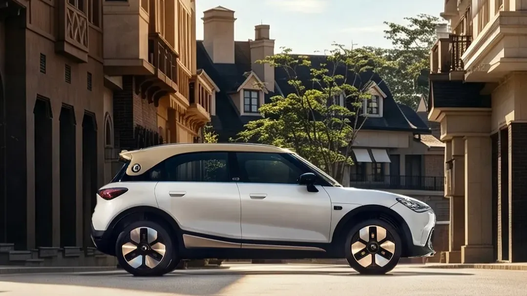 Side profile of the new smart #1 in white with a champagne-gold roof, parked on a cobblestone street.