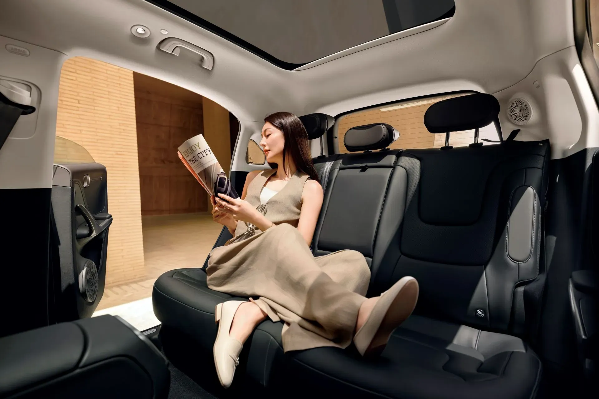 Rear cabin of the new smart #1 with a panoramic sunroof, showing a passenger reclining with feet up.