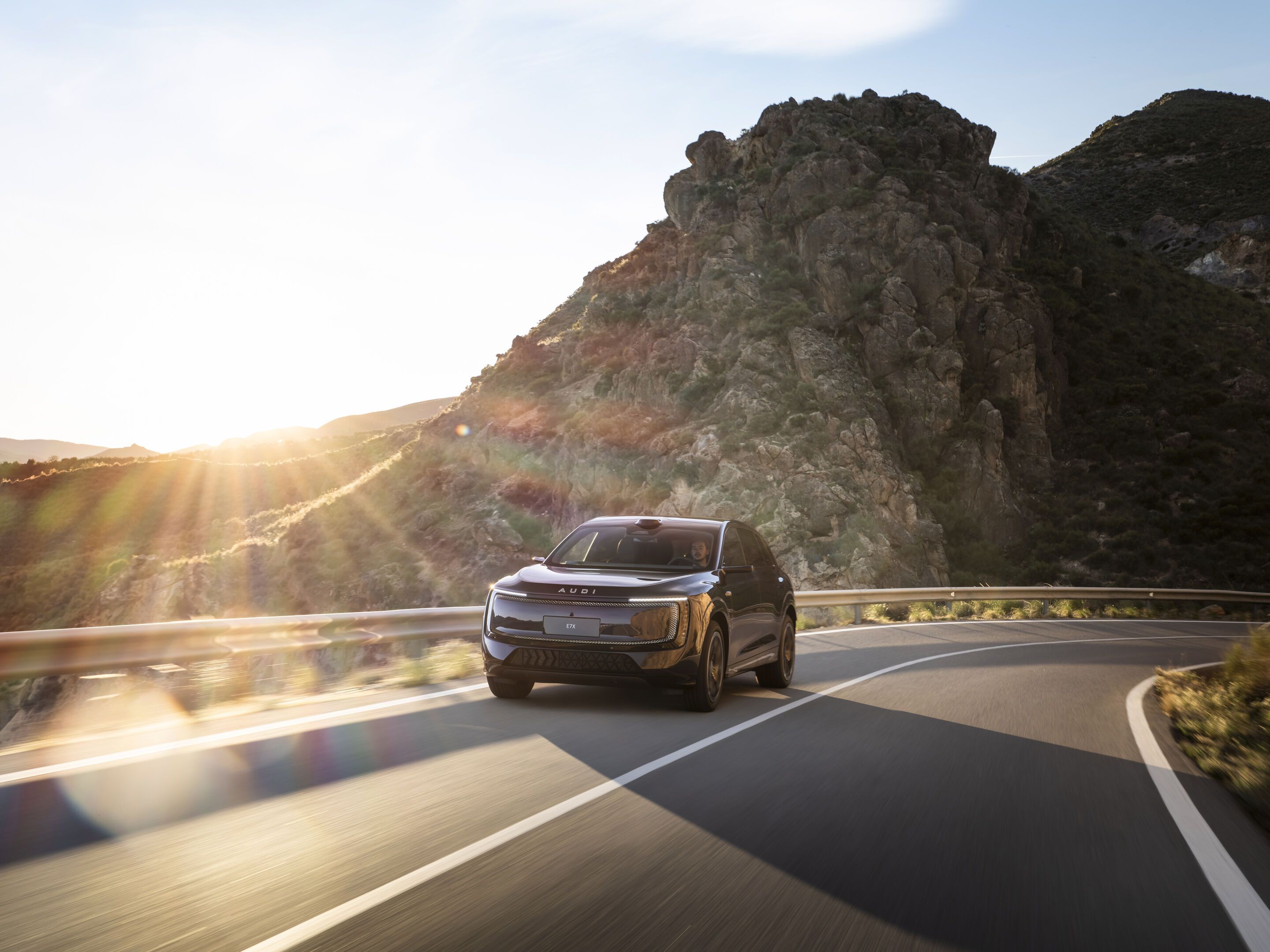 AUDI E7X pictured from the front while driving on a winding mountain road