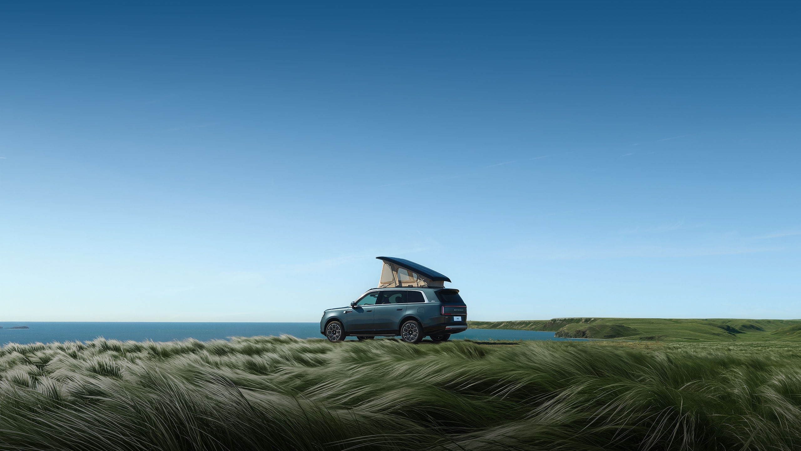 Xiaomi SkyNomad N90 Max Explorer Edition parked in a coastal grassland with its pop-up roof camper extended