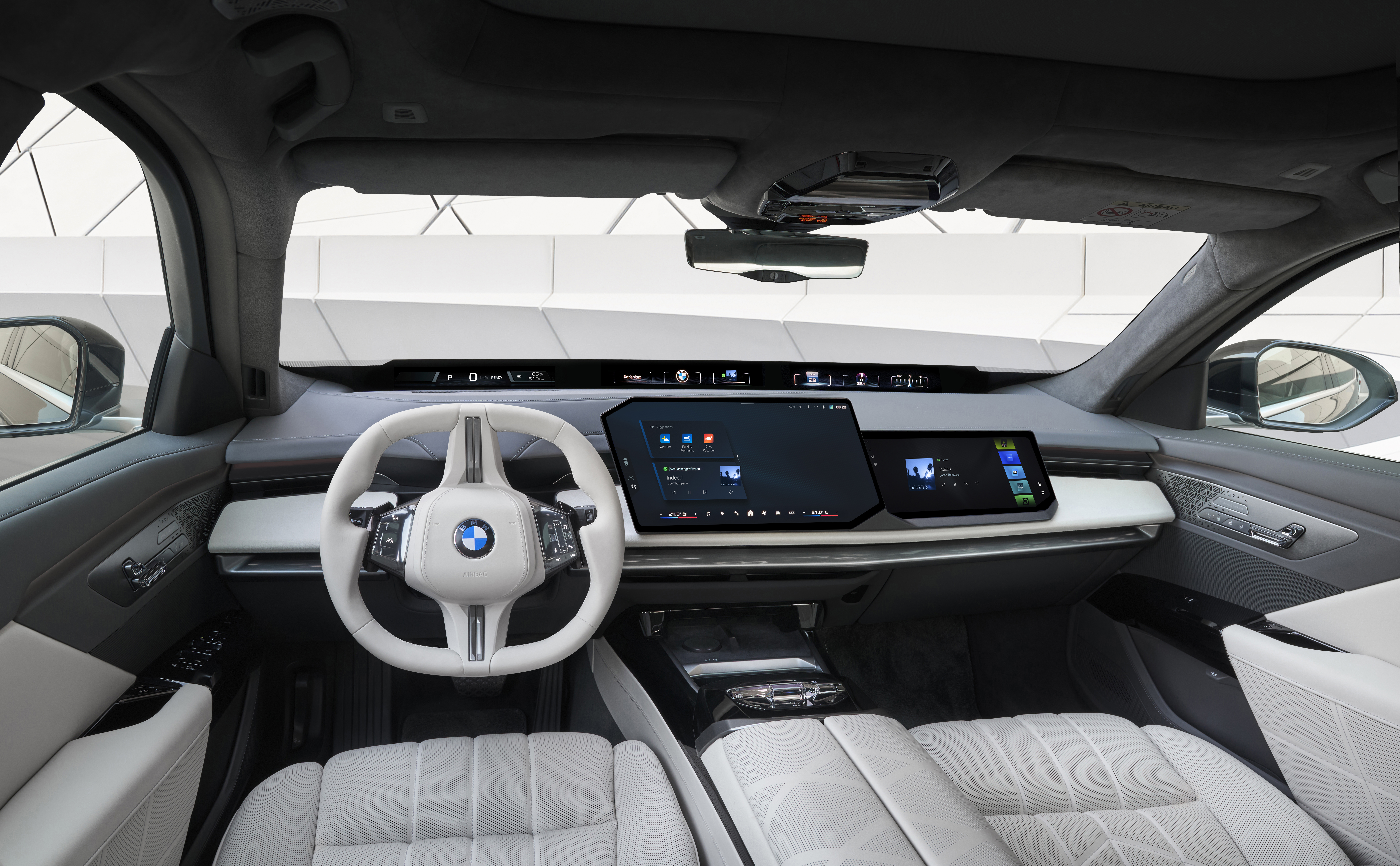 Cockpit of the new BMW 7 Series showing the steering wheel and dual curved displays of BMW Operating System X