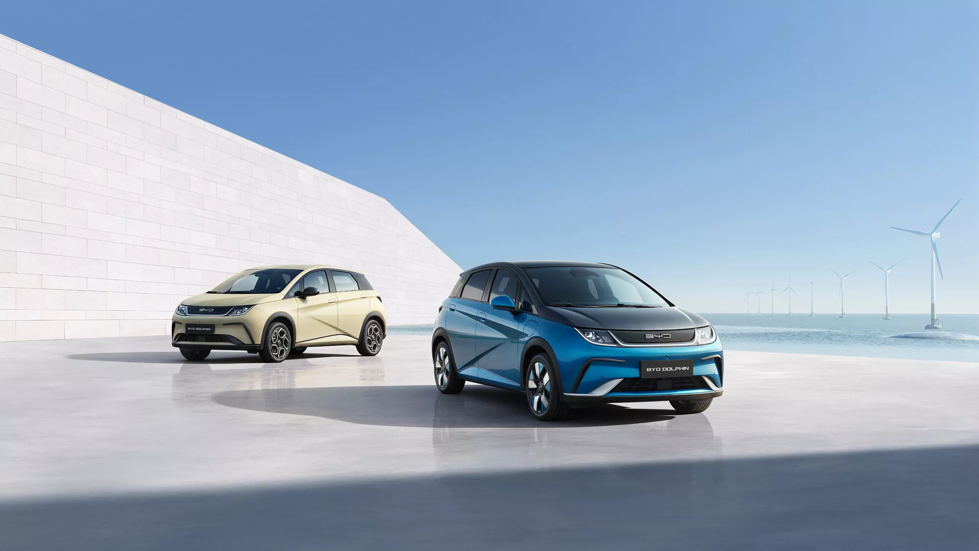 Two BYD Dolphin hatchbacks, in cream and blue two-tone, on official display, the compact model tipped as one of BYD's lower-priced Canadian entrants