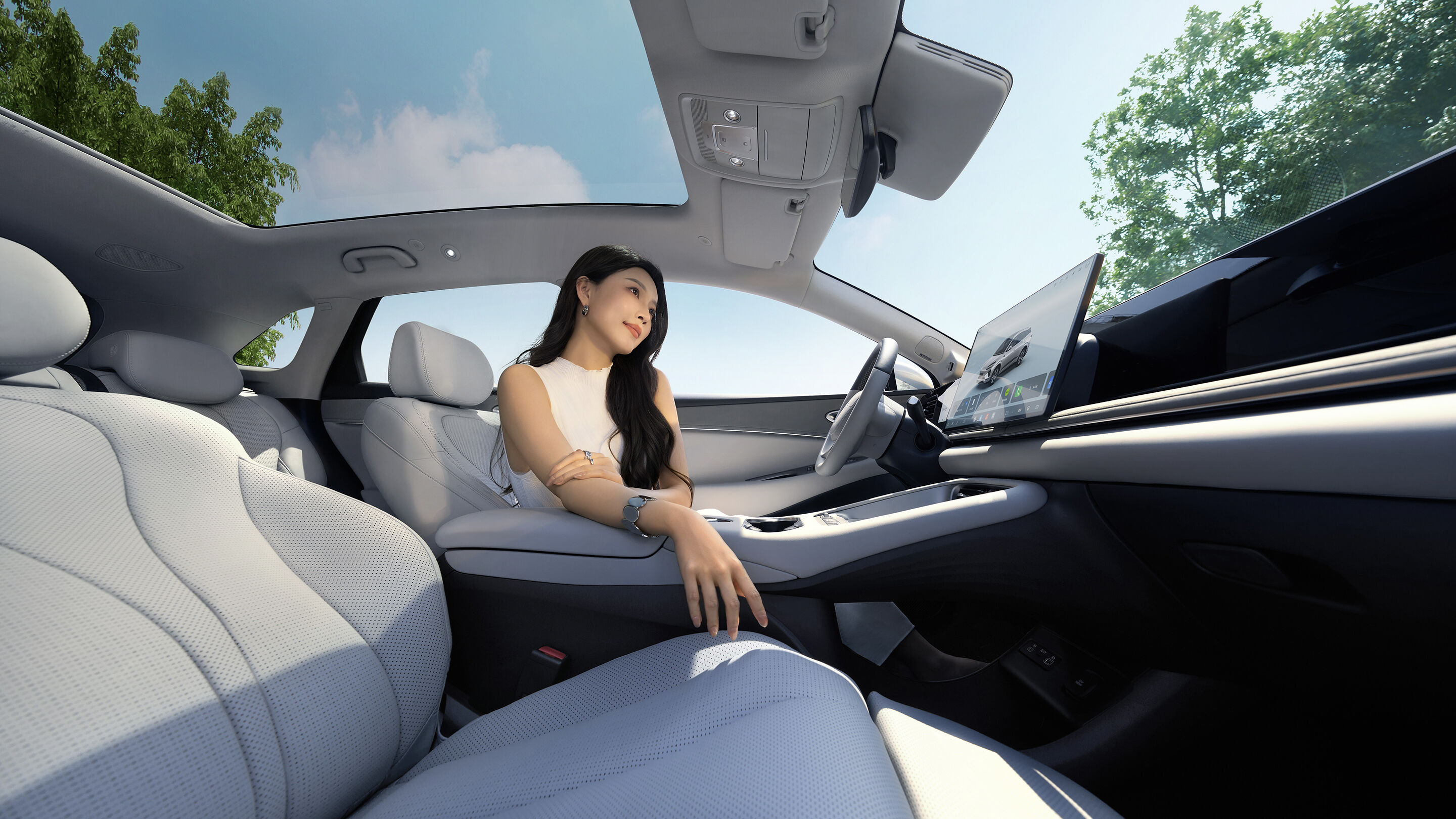 Cabin of the 2026 BYD Sealion 06 EV with a passenger seat, glass roof and tilted central display in an official image
