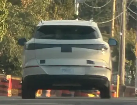 Rear view of a white camouflaged SUV in Markham, Ontario with taped badges and a full-width taillight bar