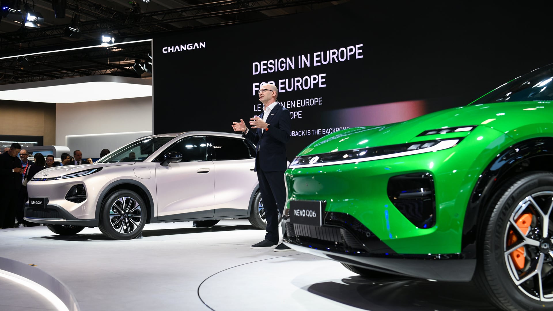 Presenter between a champagne NEVO Q05 and a green NEVO Q06 under a Design in Europe for Europe screen in Paris