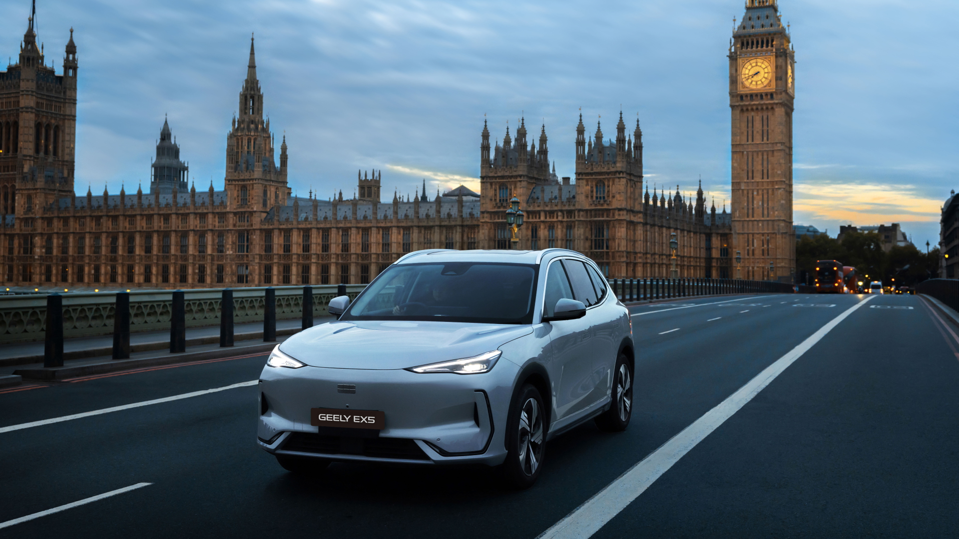 Pale silver Geely EX5 electric SUV on a London bridge with the Houses of Parliament and Big Ben behind it (Geely)