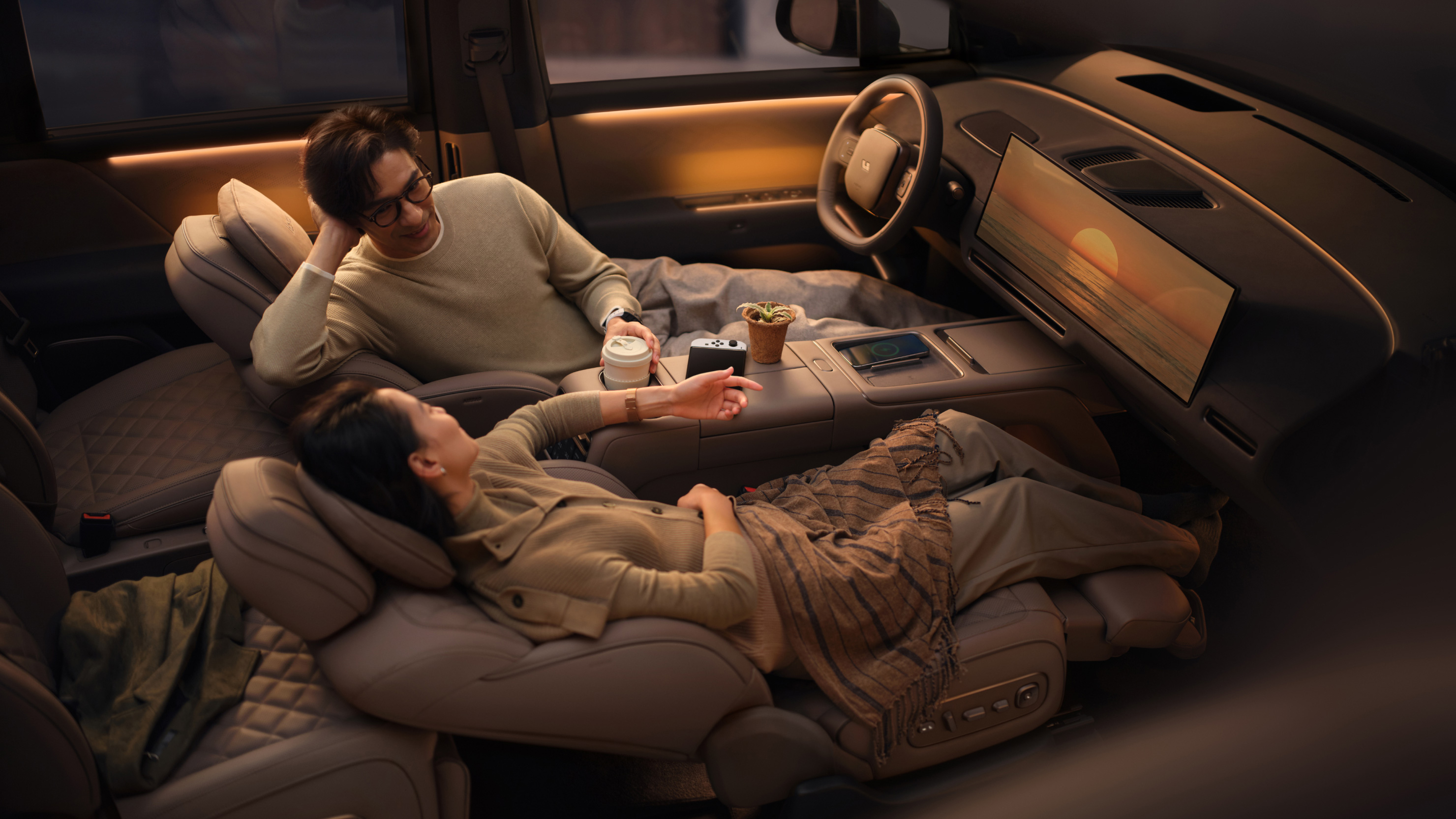 A passenger reclines fully flat in the Li Auto i9's second-row zero-gravity seat during a lounge demonstration.