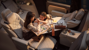 Two children use the new Li MEGA's fold-out floating table in the second row of the cabin