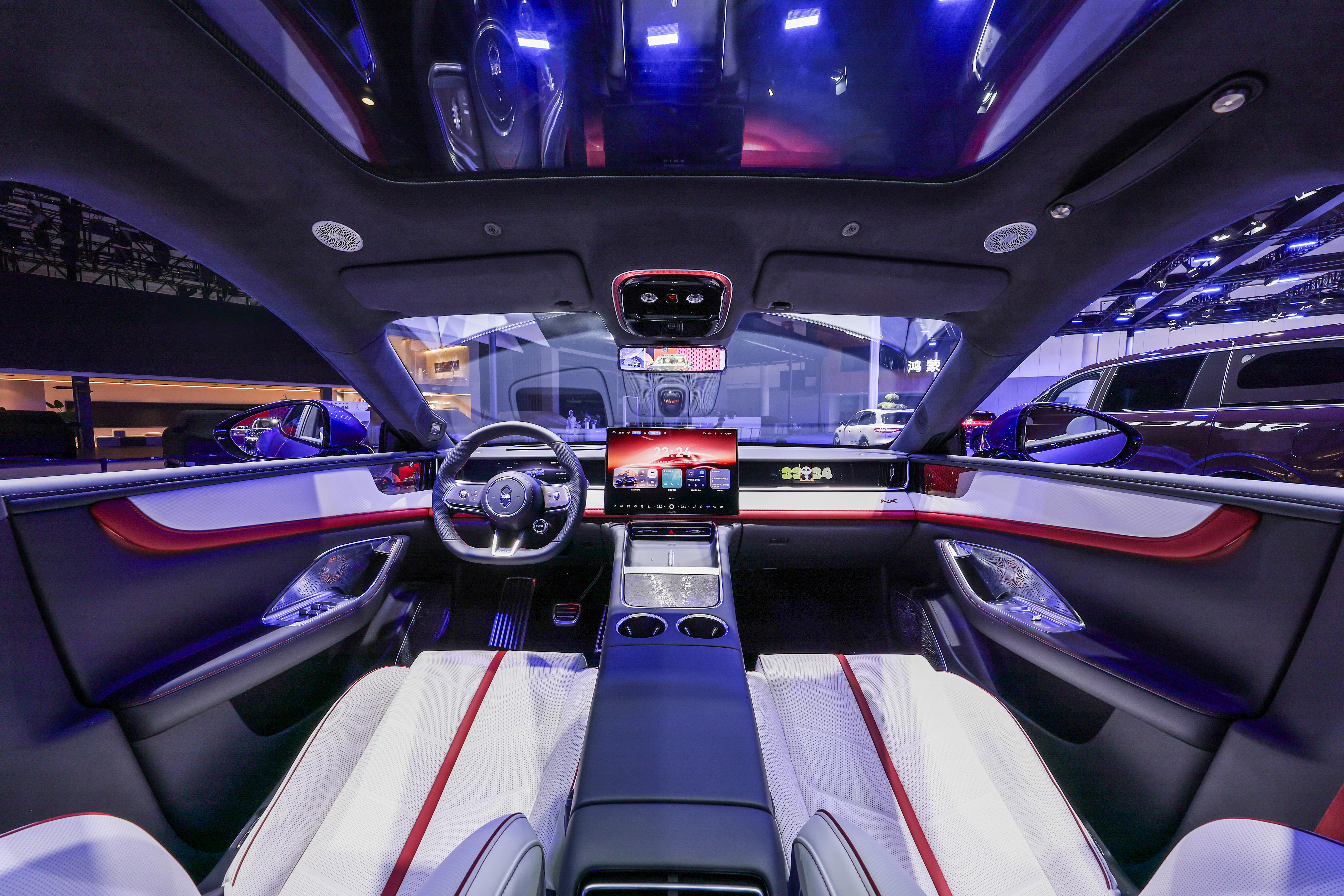 Luxeed RX cockpit with a red-accented dashboard, dual-screen center console, and panoramic glass roof at its public reveal
