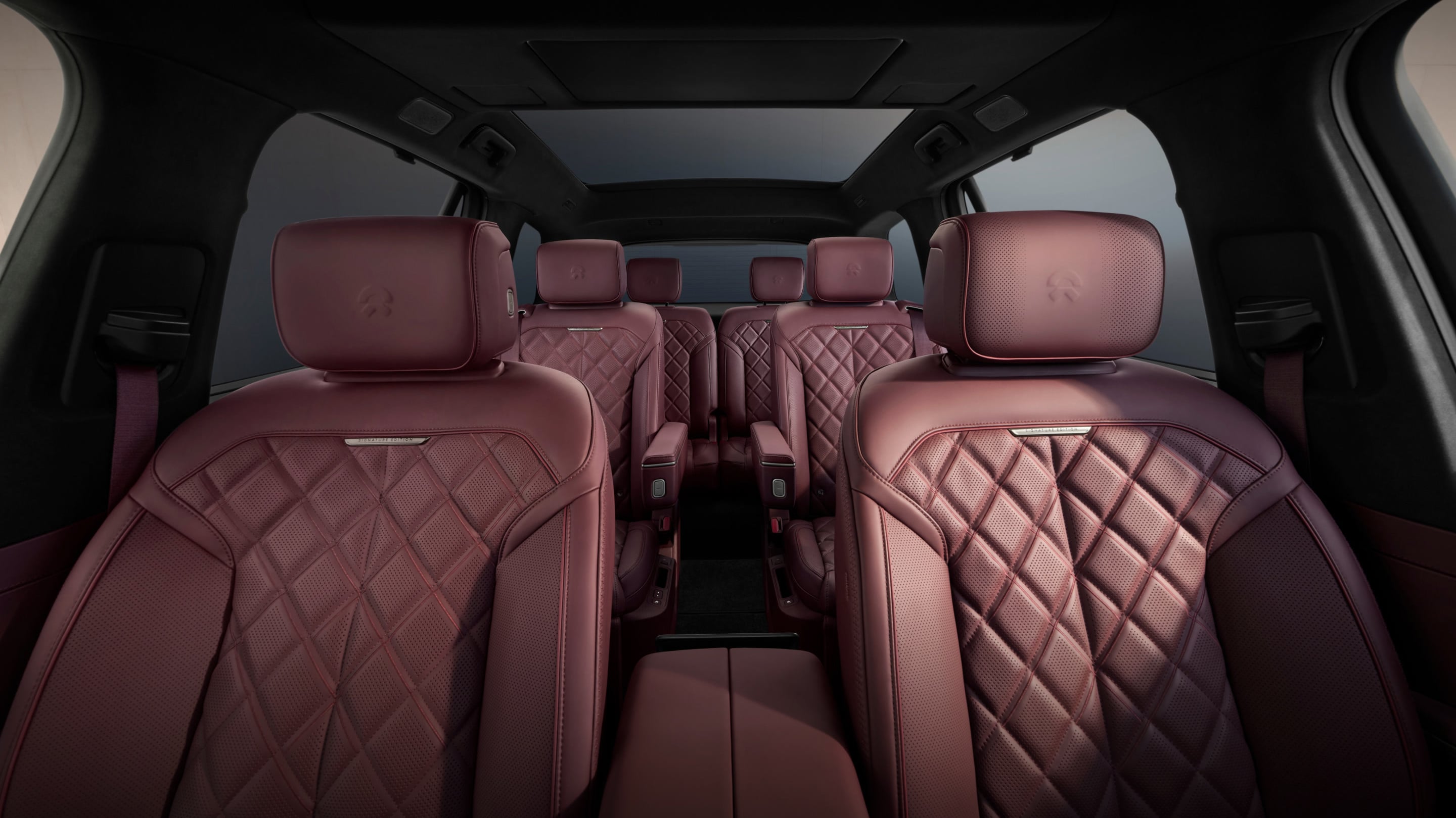 Rear-seat view of the third-generation NIO ES8's burgundy leather cabin, showing its diamond-quilted zero-gravity seats.
