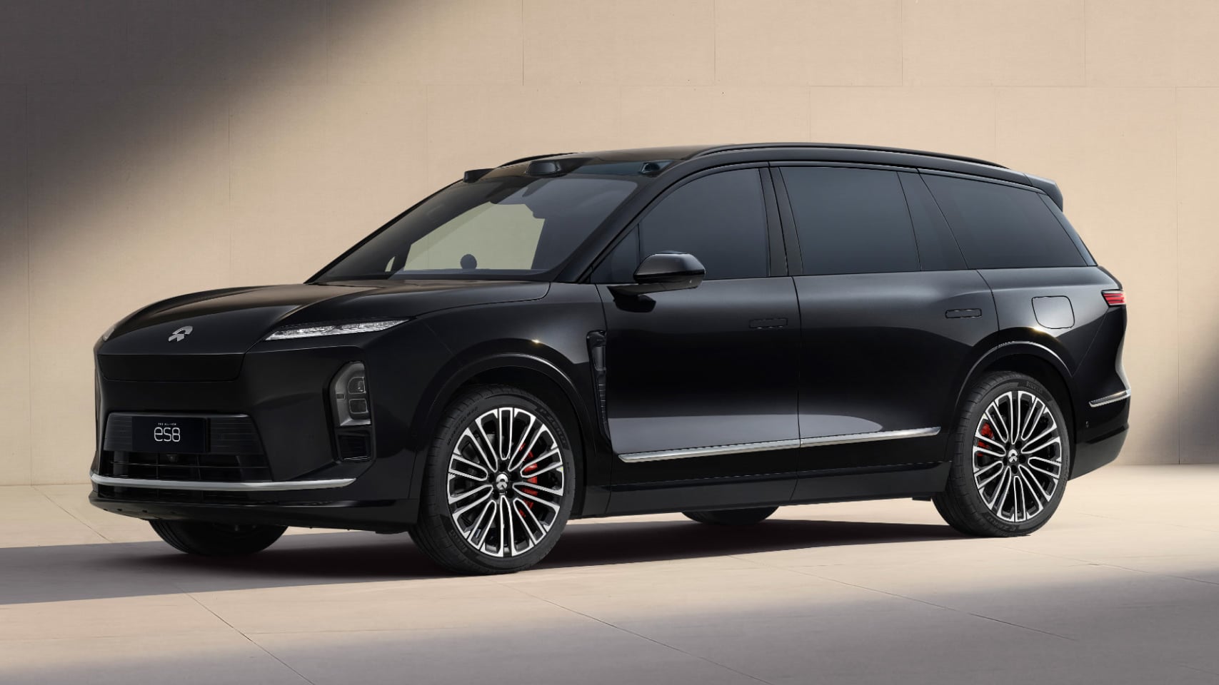 Black NIO ES8 Special Edition SUV shown in front three-quarter view in a sunlit beige studio