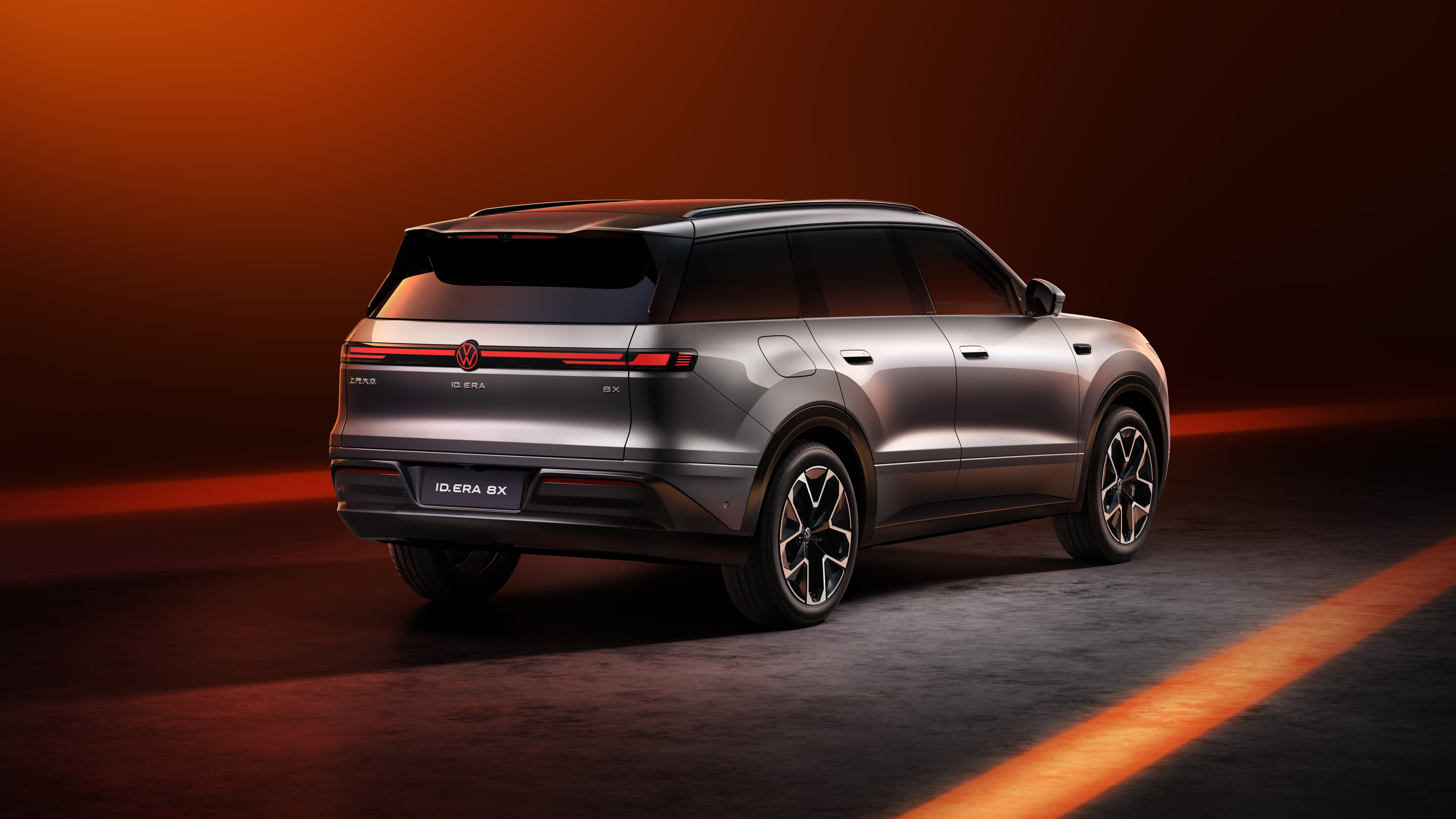 Silver SAIC Volkswagen ID. ERA 8X SUV in rear three-quarter studio view with full-width light bar and illuminated VW badge